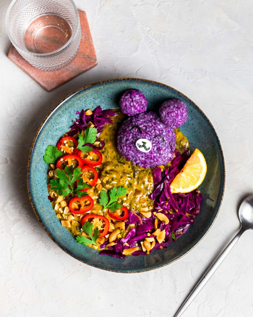 Peanut spinach curry with purple rice bear