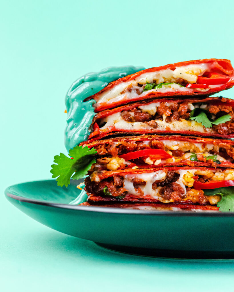 A stack of vegan quesadilla on a blue backdrop.