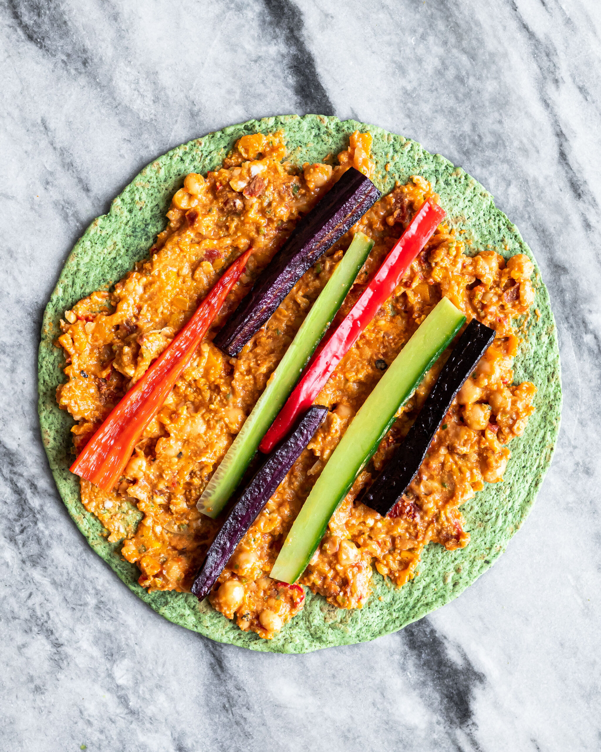 A wrap with the cream cheese spread and some extra vegetables, cucumber, carrot and bell pepper.