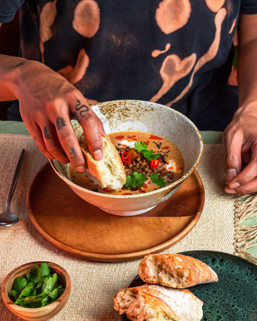 Dipping a piece of bread in the lentil coconut soup