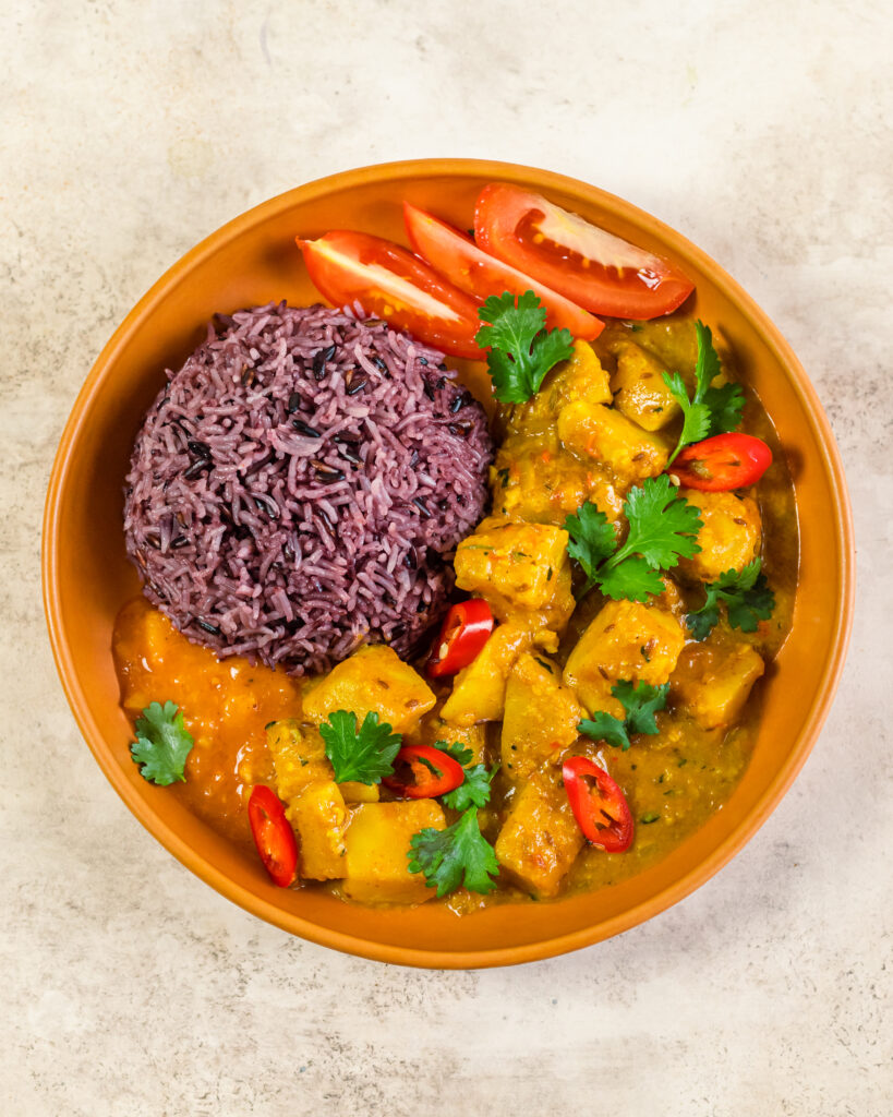 A bowl with celeriac curry and purple rice